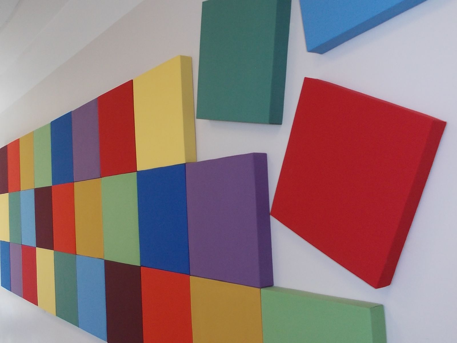 Bunte Wandabsorber in verschiedenen Formaten an einer Bürowand