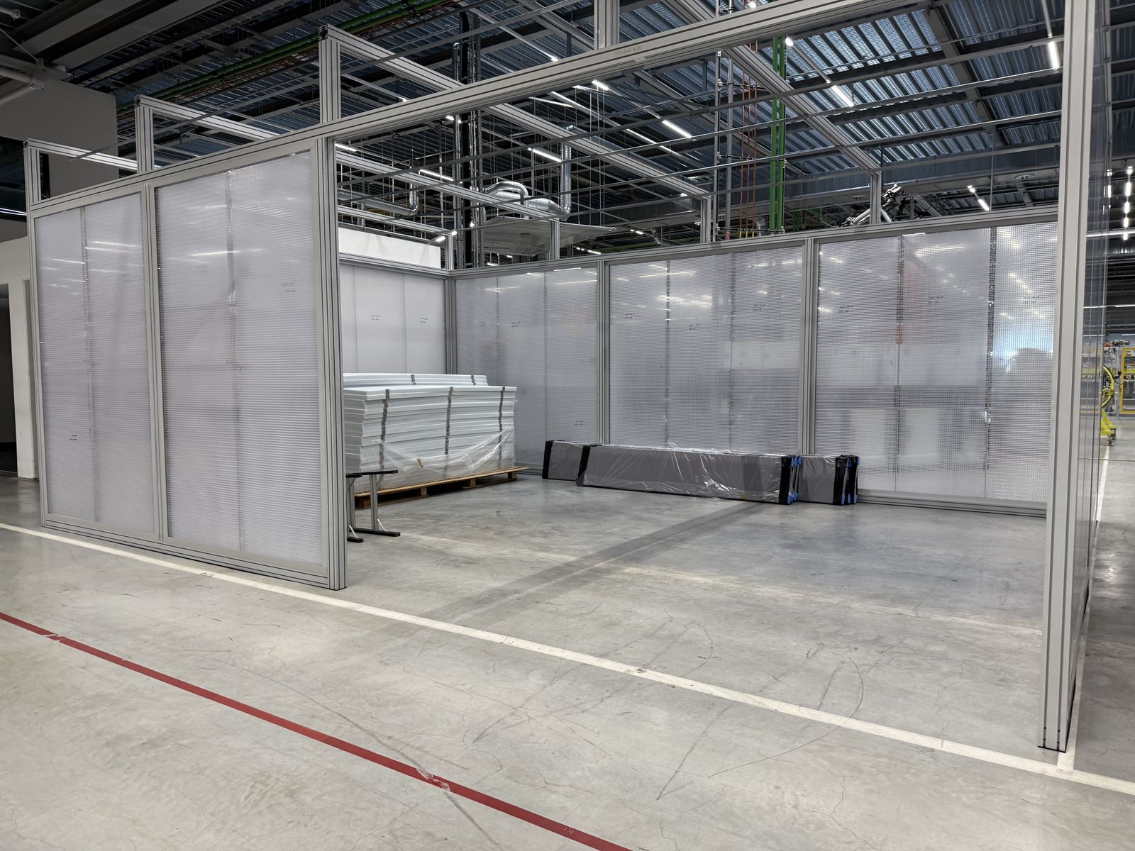 Transluzente Einhausung kapselt eine Anlage in der Halle ab