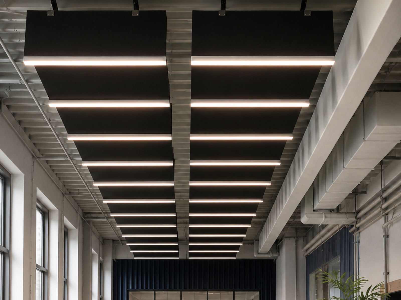 Raster abgehängter Baffeln mit Lichtleisten über der Hallenfläche