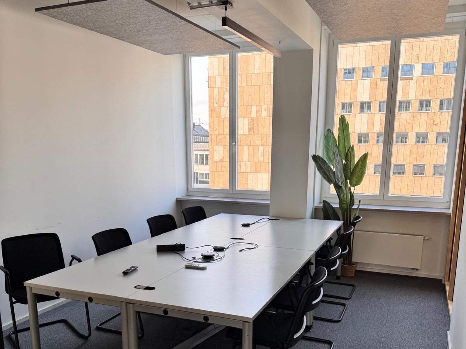 Besprechungsraum mit Deckenbaffeln über dem Tisch an der Fensterfront