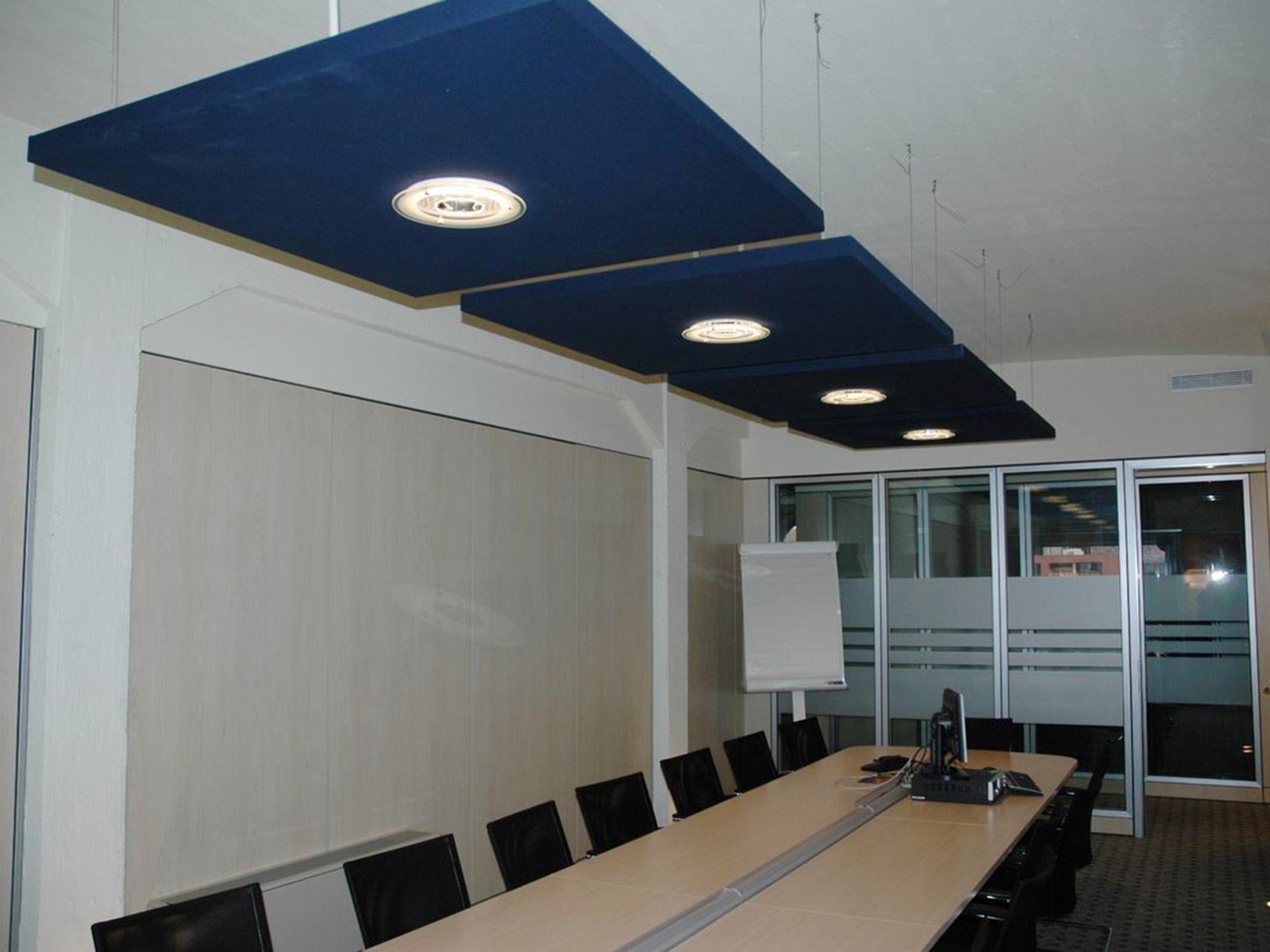 Blaue Deckensegel mit integrierten Leuchten über einem Besprechungstisch