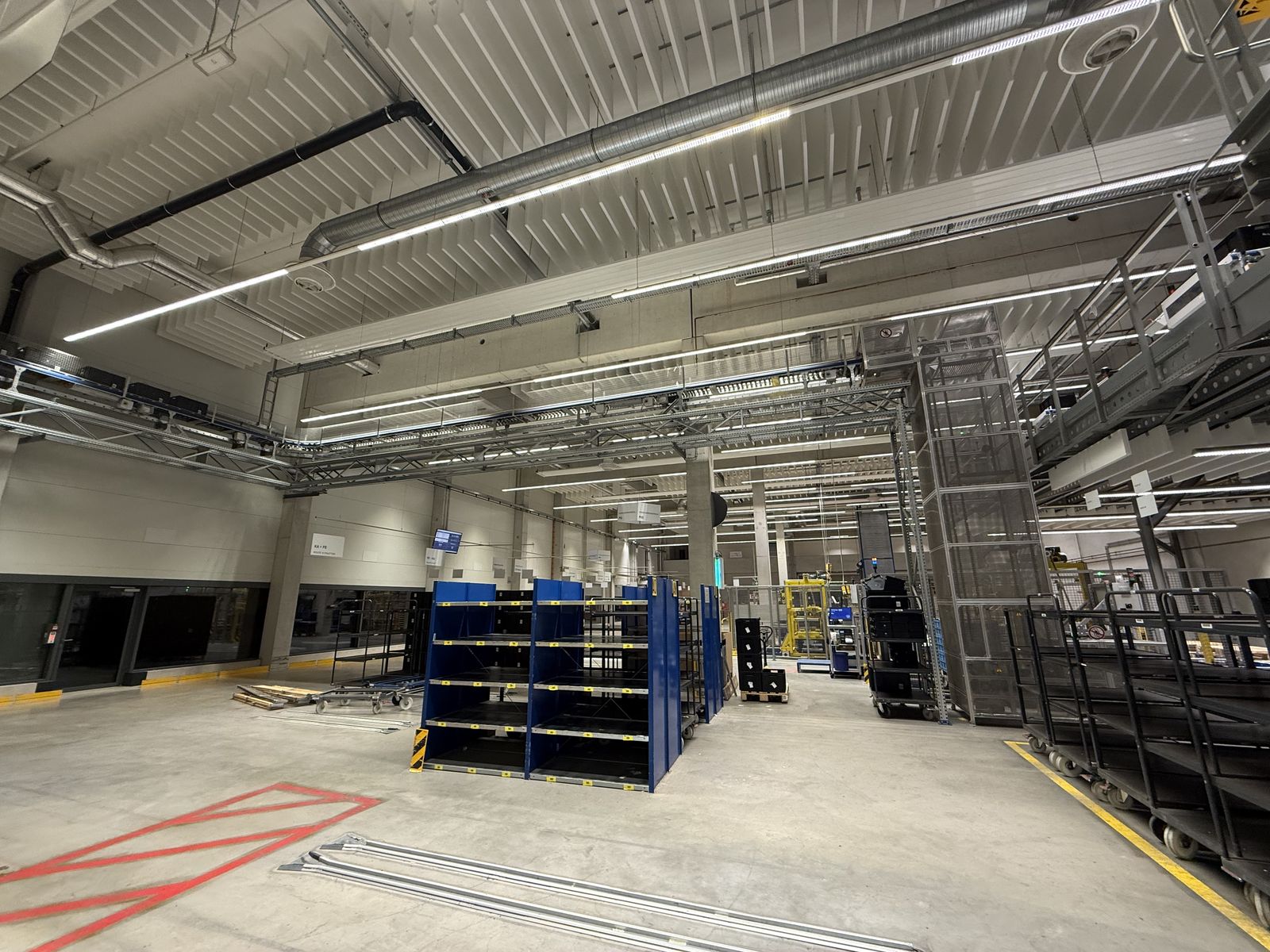 Lagerhalle mit Regalreihen und Deckenabsorbern unter dem Hallendach