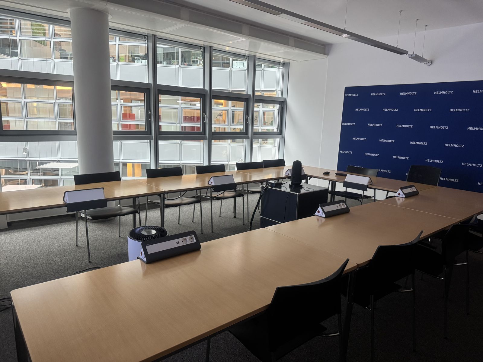 Seminarraum mit Deckenabsorbern und Konferenztechnik an der Fensterfront