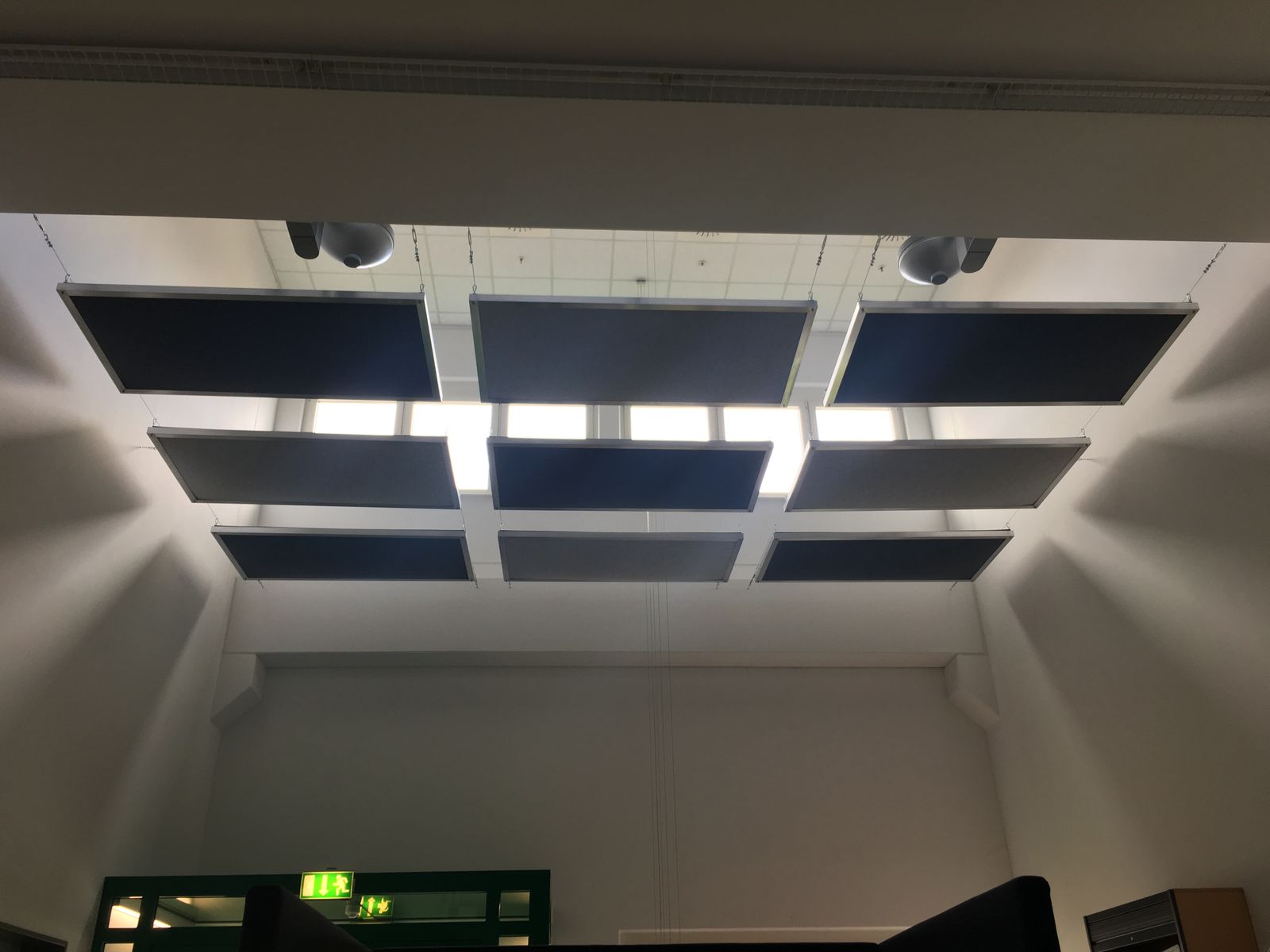 Blaue Deckenabsorber im Raster an der Decke eines Technikraums