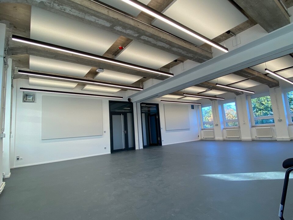 Deckenabsorber zwischen Betonträgern einer Sporthalle