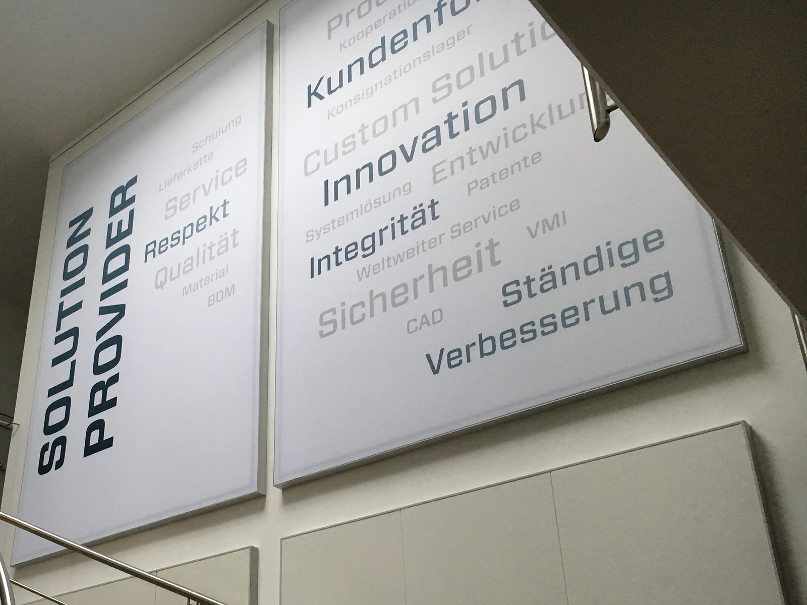 Zwei bedruckte Akustikbilder mit Wortwolke im Treppenhaus eines Unternehmens