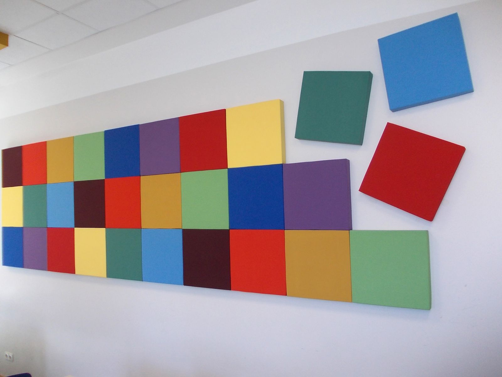 Farbige Breitbandabsorber als Wandcollage in einem Unterrichtsraum