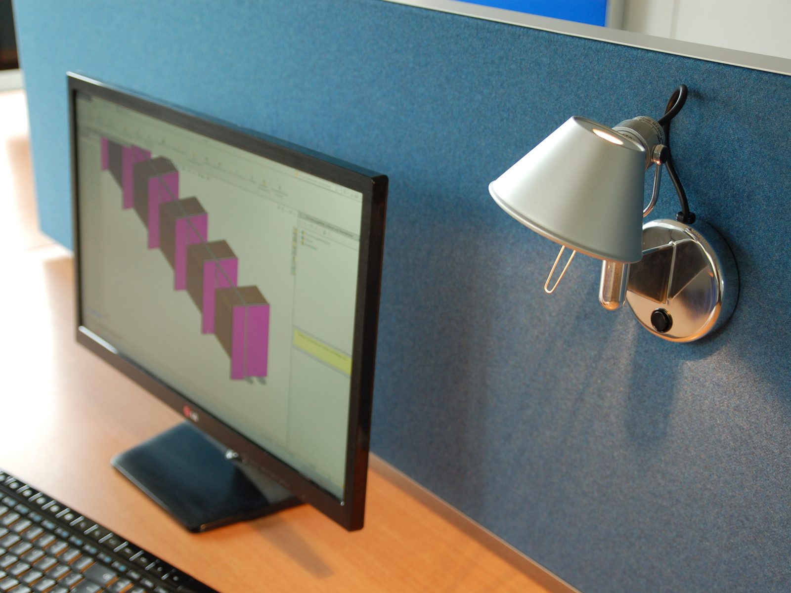 Schreibtischabsorber mit angeklemmter Arbeitsplatzleuchte am Monitor