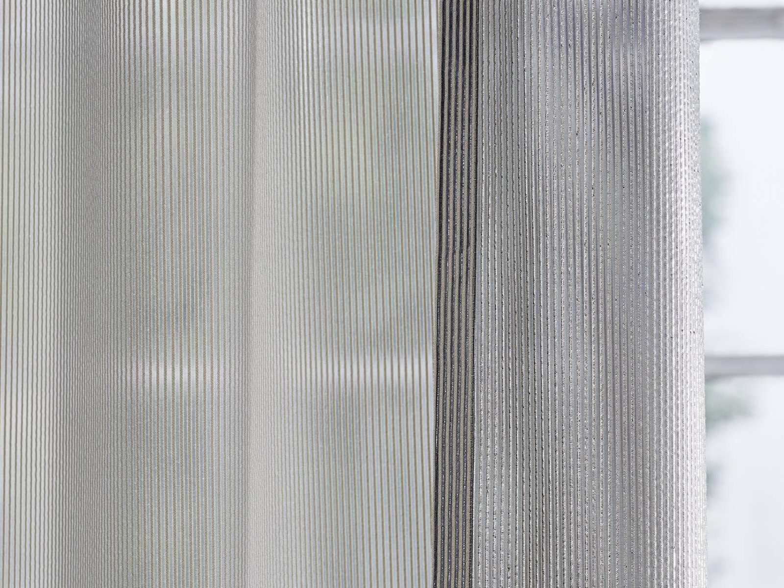 Farbvarianten eines transparenten Akustikstoffs nebeneinander